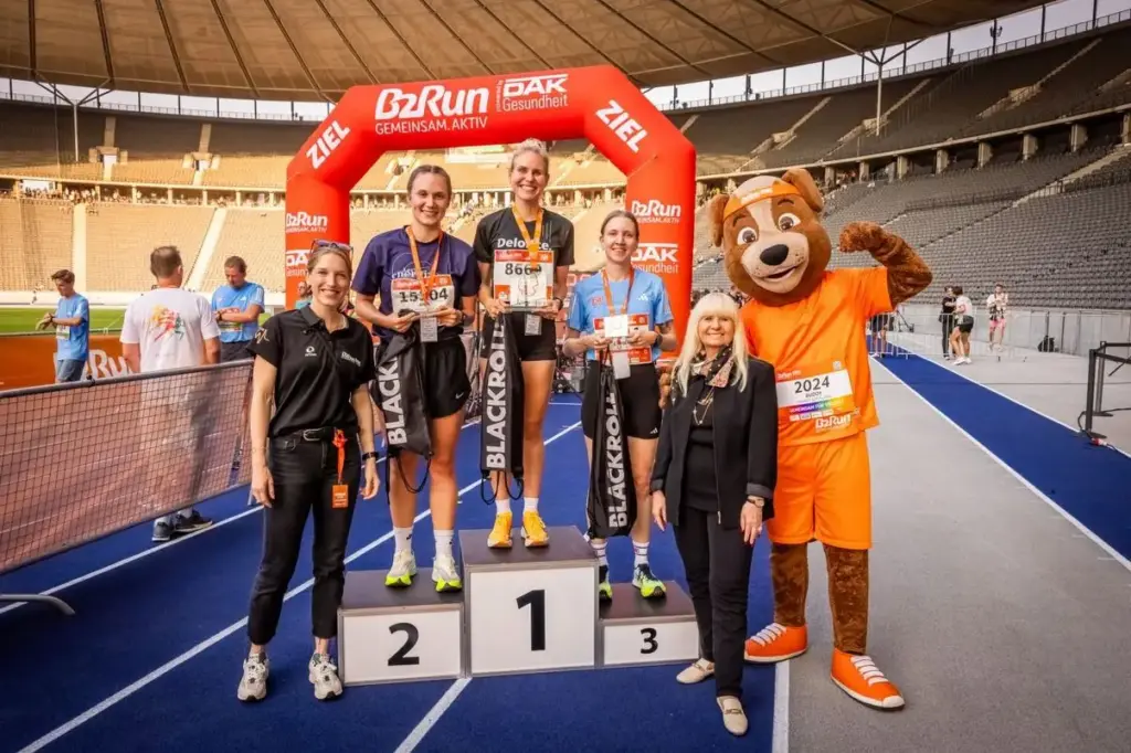 Firmenlauf Berlin - B2Run am 17.9.2024 im Berliner Olympiastation. Die Siegerinnen. Im Hintergrund links das ETL Shirt mit dem Grafik Logo der vier Läufer, getragen von Online Redakteur Armin Ceric.